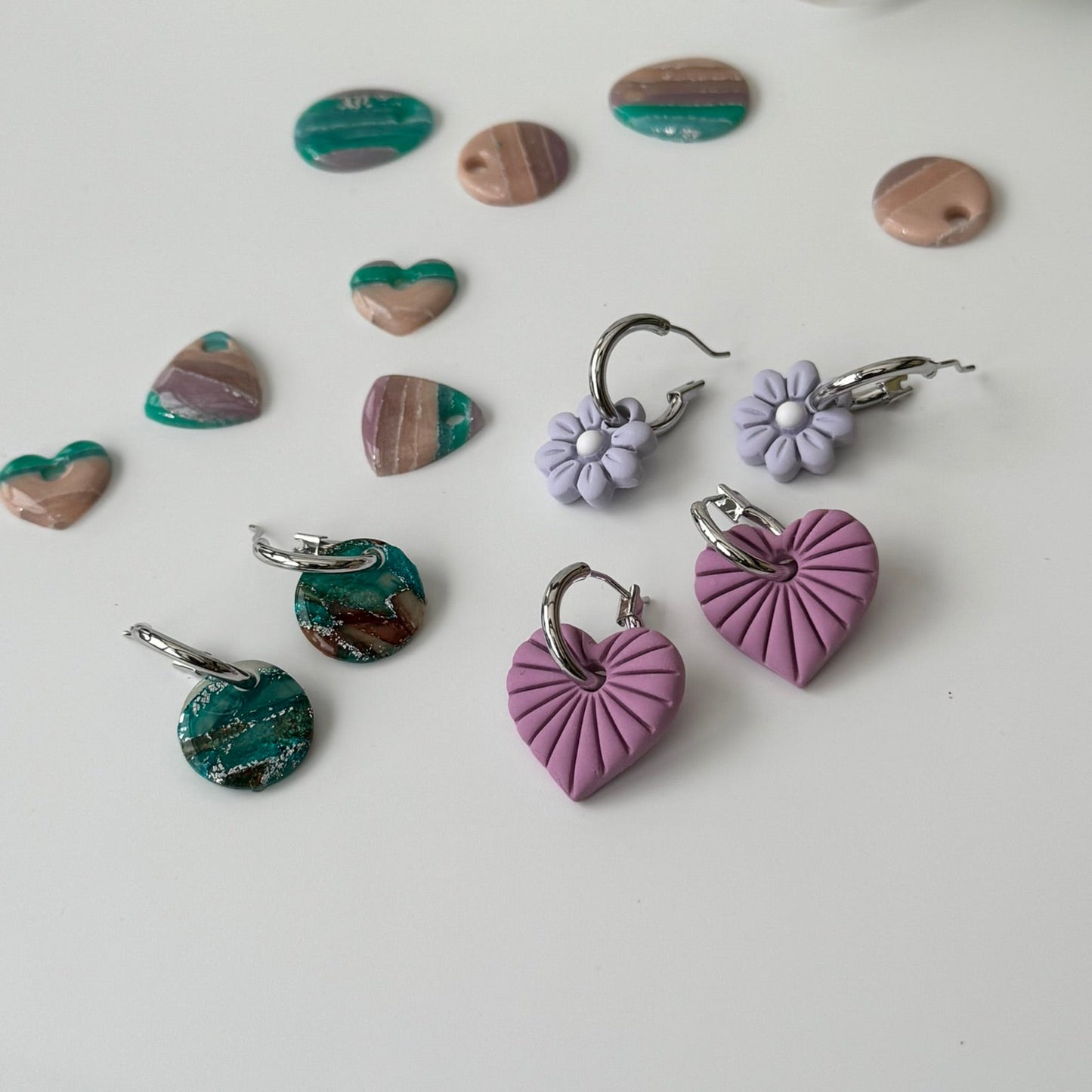Heart-shaped earrings in various colors on a light background