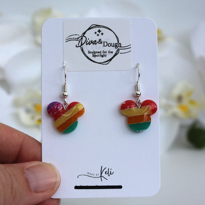 Colorful heart-shaped earrings on a 'Diva & Dough' branded card held by a hand.