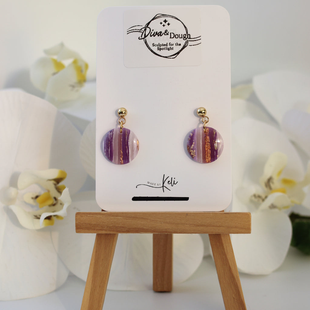 Pair of earrings on a display card with decorative flowers in the background