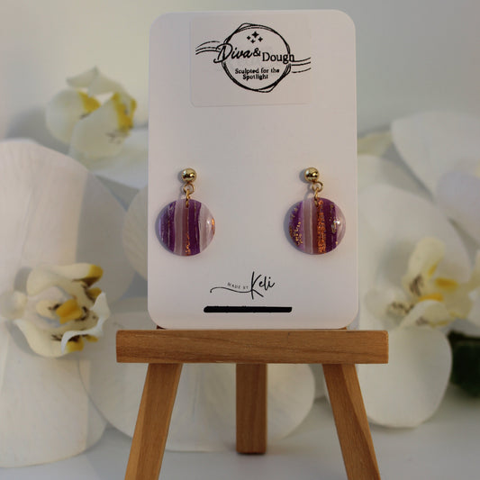 Pair of earrings on a display card with decorative flowers in the background